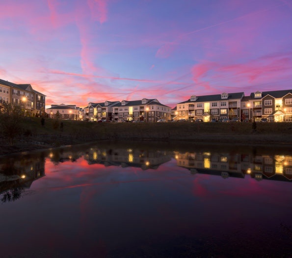 Elm Street Development apartment complex at sunset overlooking pond
